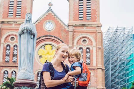 Mom and son in the background Notre dame de Saigon Cathedral, build in 1883 in Ho Chi Minh city, Vietnam.の写真素材