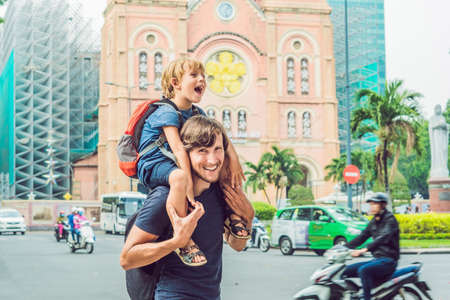 Father and son in the background Notre dame de Saigon Cathedral, build in 1883 in Ho Chi Minh city, Vietnam.の写真素材