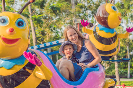 Mom and son having fun at an amusement park.の写真素材