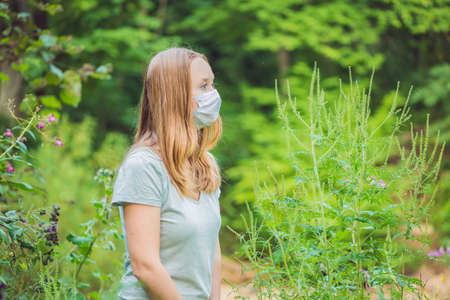 Young woman in a medical mask because of an allergy to ragweed.