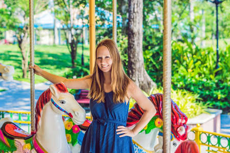 Woman enjoying in funfair and riding on colorful carousel house.の写真素材