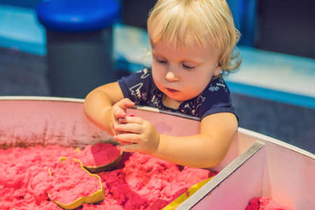 Boy playing with kinetic sand in preschool. The development of fine motor concept. Creativity Game concept.の写真素材