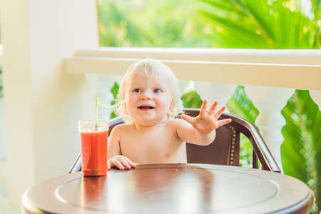 Happy toddler boy drinking healthy selfmade smoothie.の写真素材