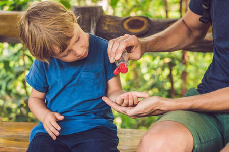 Father and son using wash hand sanitizer gel in the park before a snack.の写真素材
