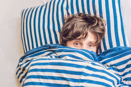 Man sleeping on his bed in bedroom at home.の写真素材