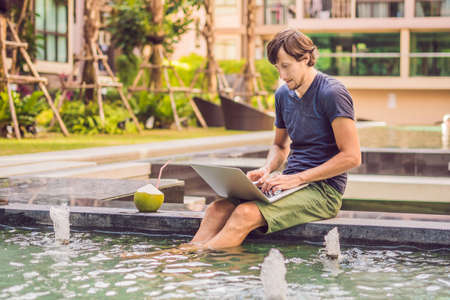 Young freelancer working on vacation next to the swimming pool.の写真素材