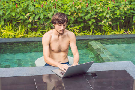 Young freelancer working on vacation next to the swimming pool.の写真素材