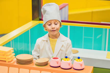 The boy plays the game as if he were a cook or a baker in a children's kitchen.の写真素材