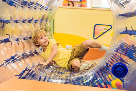 Cute little boy, playing in Zorb a rolling plastic cylinder ring with a hole in the middle, intdoor.の写真素材