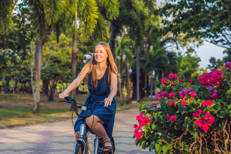 young beautiful woman riding a bicycle in a park. Active people. Outdoorsの写真素材
