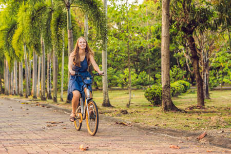 young beautiful woman riding a bicycle in a park. Active people. Outdoorsの写真素材