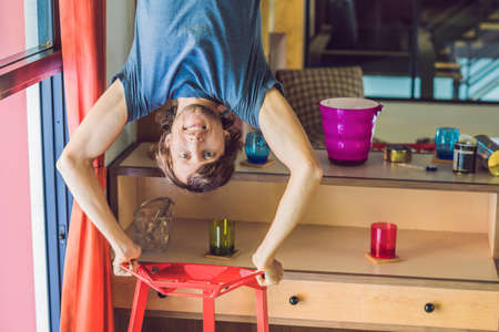 A man stands on his hands upside down in the kitchen.の写真素材