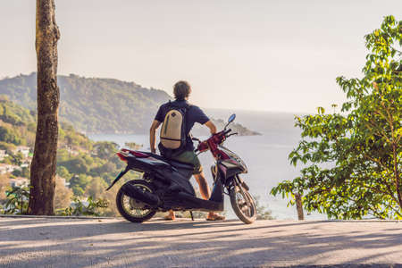 A man on a motorbike against the sea.
