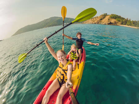happy family with kid kayaking at tropical ocean.の写真素材
