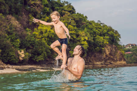 father and son playing on the beach at the day timeの写真素材