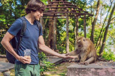 The man feeds the monkey whith nuts.の写真素材