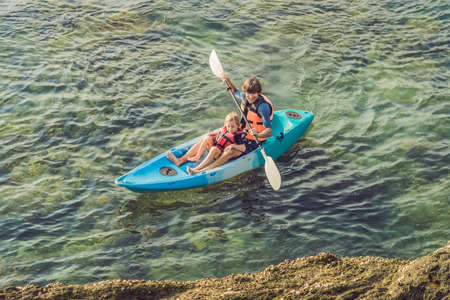 Father and son kayaking at tropical ocean. Travel and activaties with children concept.の写真素材
