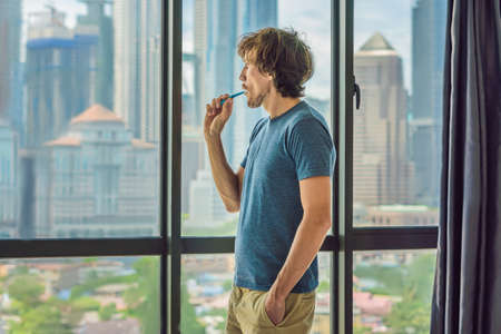 Young man brushing his teeth in his bathroom.