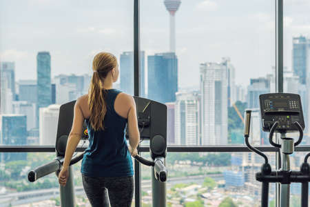sport, fitness, lifestyle, technology and people concept - woman exercising on treadmill in gym...