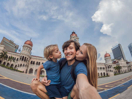 happy family makes selfie on background of Merdeka square and Sultan Abdul Samad Building.の写真素材