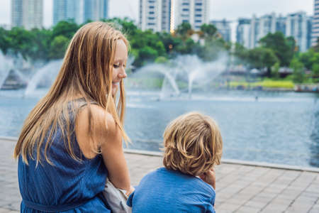Happy mom with little son enjoying water fountains.の写真素材