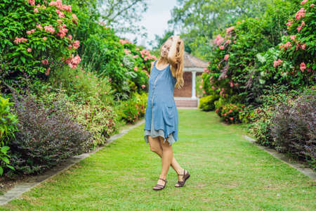 Young woman enjoying a beautiful blooming garden.の写真素材