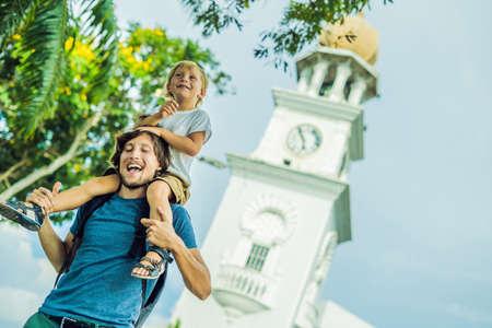 Father and son of tourists in the background of Queen Victoria Memorial clock tower, Penang.の写真素材