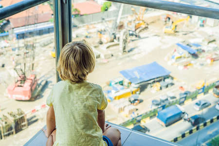 The boy is looking at the construction site.の写真素材