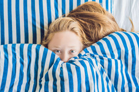 Beautiful young woman lying down in bed and sleeping. Do not get enough sleep concept.の写真素材