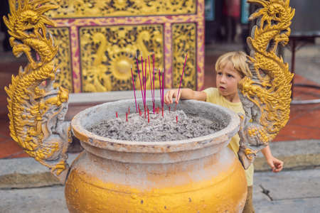 Incense sticks on joss stick pot are burning and smoke use for pay respect to the Buddha, Incense sticks in boy hand and smoke use for pray respect to the Buddha in Buddhism life.の写真素材