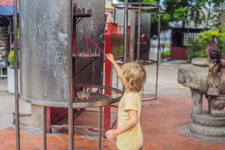 Incense sticks on joss stick pot are burning and smoke use for pay respect to the Buddha, Incense sticks in boy hand and smoke use for pray respect to the Buddha in Buddhism life.の写真素材