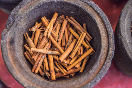 Cinnamon sticks in a pot against the background of other spices.の写真素材