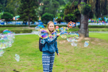Young woman is playing with big bubbles outdoor.の写真素材