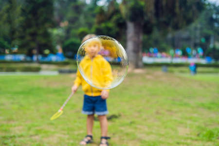 Cute little boy is playing with big bubbles outdoor.の写真素材
