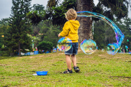 Cute little boy is playing with big bubbles outdoor.の写真素材