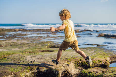 The boy is playing on the cosmic Bali beach.. Portrait travel tourist. Positive human emotions,...