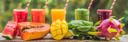 Rainbow from smoothies. Watermelon, papaya, mango, spinach and dragon fruit. Smoothies, juices, beverages, drinks variety with fresh fruits on a wooden table. BANNER, long formatの写真素材
