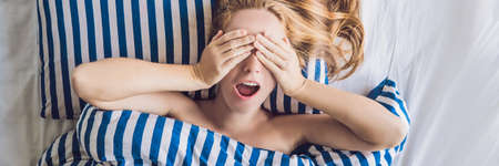 Beautiful young woman lying down in bed and sleeping. Do not get enough sleep concept. BANNER, long formatの写真素材