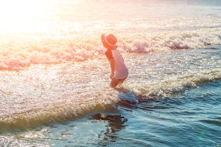 happy little boy running on sand tropical beach.の写真素材