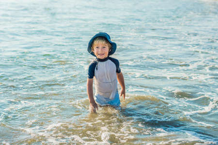 happy little boy running on sand tropical beach.の写真素材