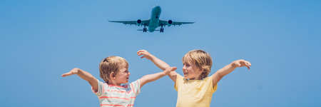 Two happy boys on the beach and a landing plane. Traveling with children concept. BANNER, long...