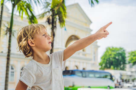 Boy on background of Old Town Hall in George Town in Penang, Malaysia. The foundation stone was laid in 1879. Traveling with children concept.の写真素材