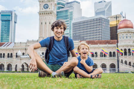 Dad and son on background of Merdeka square and Sultan Abdul Samad Building. Traveling with children concept.の写真素材