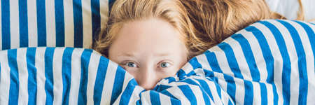 BANNER Beautiful young woman lying down in bed and sleeping. Do not get enough sleep concept. long formatの写真素材