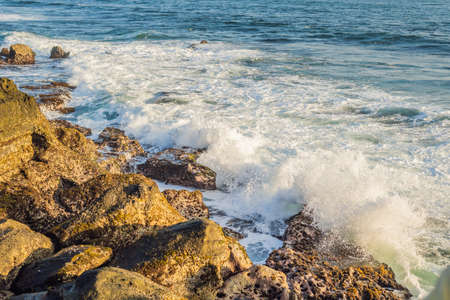 Big waves breaking on the shore with sea foam.