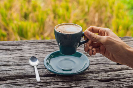 A man's hand holds a cup of coffee