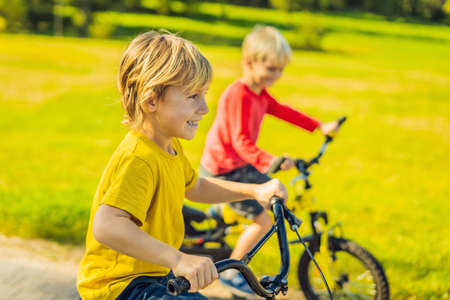 Two happy boys cycling in the park.の写真素材