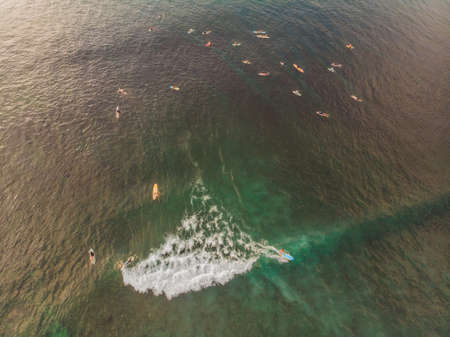Surfers on the waves in the ocean, top view.