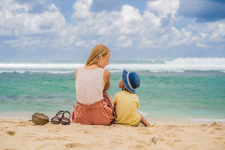 Mom and son travelers on amazing Melasti Beach with turquoise water, Bali Island Indonesia.の写真素材