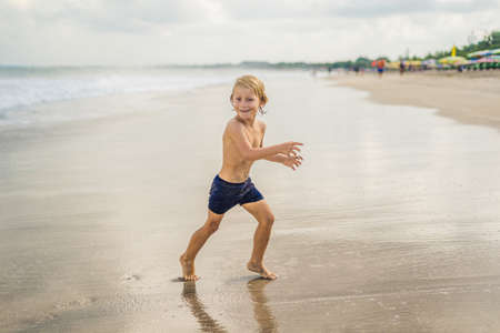 Boy playing on the beach in the water.の写真素材